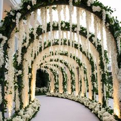 an archway decorated with white flowers and greenery for a wedding ceremony or reception venue