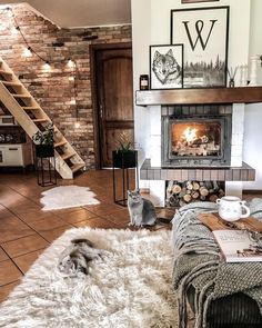 a living room filled with furniture and a fire place next to a staircase leading up to the second floor