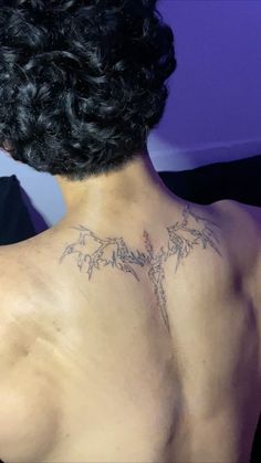 the back of a man with tattoos on his chest