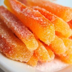 some sugared oranges are on a white plate