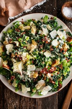 a white bowl filled with lots of food on top of a wooden table