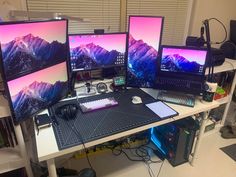 three computer monitors sitting on top of a desk next to a keyboard and monitor screen