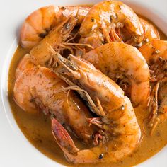 a white plate topped with cooked shrimp and gravy