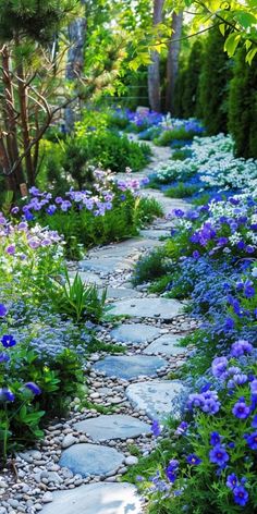 a stone path surrounded by blue flowers and greenery