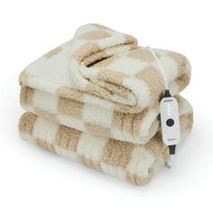 two brown and white towels stacked on top of each other with an electric outlet plugged in