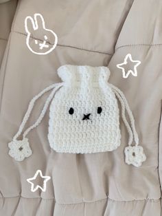 a crocheted bunny bag sitting on top of a bed next to some stars