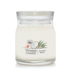 yankee coconut candle in a glass jar on a white background with the words yankee candles