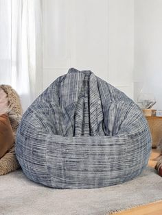 a cat laying on the floor next to a bean bag chair