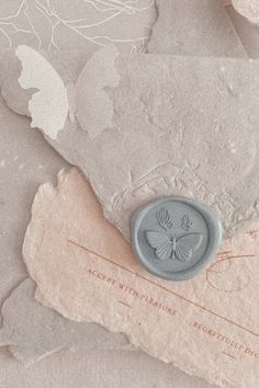 a butterfly wax stamp sitting on top of a piece of paper