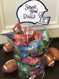 a bowl full of candy with a super bowl sign in the middle and footballs around it