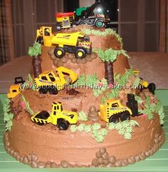 a birthday cake made to look like a construction site with trucks and trees on top