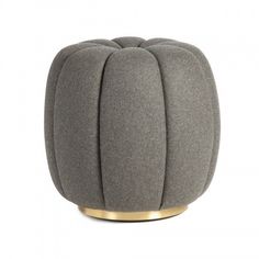 a grey ottoman with gold accents on the top and bottom, sitting in front of a white background