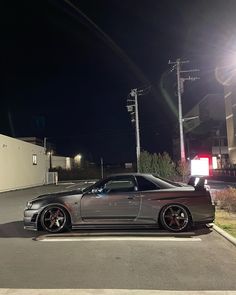 a silver sports car parked on the street at night