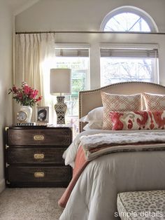 a bedroom with a bed, dresser and window