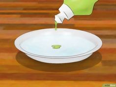 someone is pouring green liquid into a white bowl