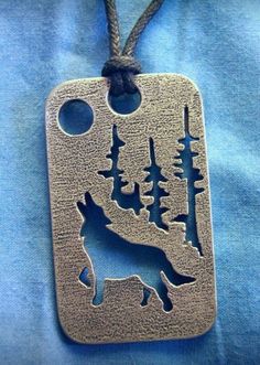 a metal dog tag with trees on it