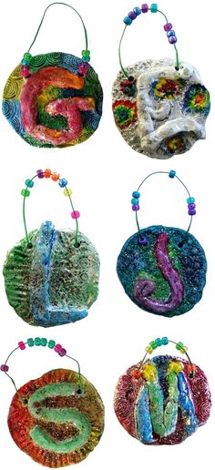 six handmade purses with beaded handles and beads hanging from the sides, all decorated in different colors