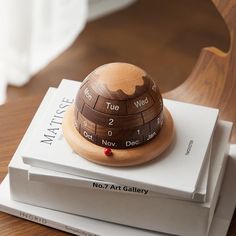 two books stacked on top of each other with a small wooden object sitting on top of them