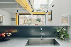 a modern kitchen with stainless steel sink and yellow accents