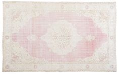 a pink and white rug with an ornate design on the bottom, in front of a white background