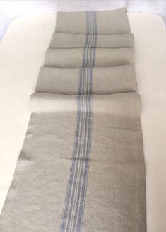 four pieces of linen folded on top of each other with blue and white striped stripes