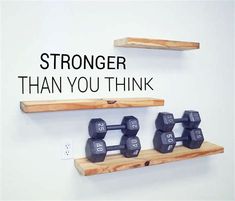 two wooden shelves with dumbs on them and the words, stronger than you think