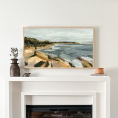 a white fireplace with a painting on the mantle