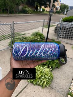 a person holding up a blue speaker with the word dixie on it's side