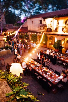 an overhead view of a restaurant with people sitting at tables and lights on the patio