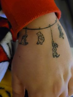 a person's hand with tattoos on it and a string attached to the wrist