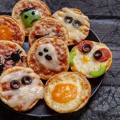 a plate filled with mini pizzas topped with faces and eyes on top of each other