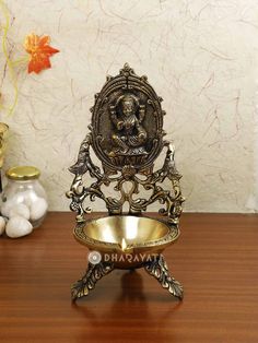 an ornate brass bowl on a wooden table