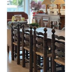 a dining room table and chairs in front of a large window with lots of windows