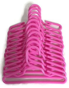 a pink plastic object on a white surface with clippings attached to the top