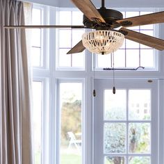 a ceiling fan in front of a window