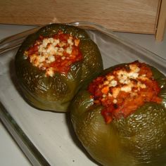 two stuffed peppers sitting on top of a stove