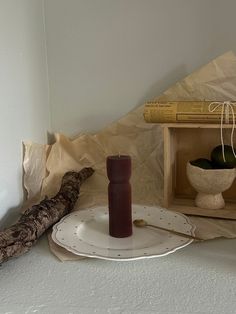 a table topped with plates and vases on top of a white counter next to a wooden box