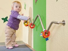 toys on a railing for babies wanting to pull up and stand Sensory Room Mural, Daycare Toys Ideas, Church Nursery Toys, Infant And Toddler Classroom Set Up, Baby Daycare Room, Sensory Wall For Toddlers, Infant Daycare Room Ideas, Daycare Infant Room Ideas, Church Nursery Ideas