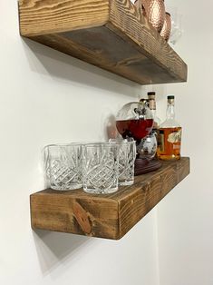 two wooden shelves with glasses and bottles on them