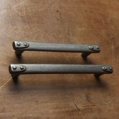 two metal handles on a wooden table