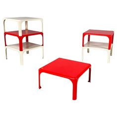 three red and white tables sitting next to each other on top of a white floor