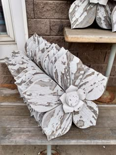 a white flower sitting on top of a wooden bench