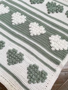 a crocheted blanket with four leaf clovers on it