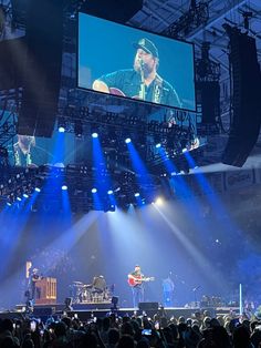 the concert is being played on stage with bright blue lights shining down at the audience