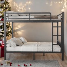 the bunk bed is next to a christmas tree with lights on it and presents scattered around