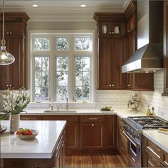 a kitchen filled with lots of wooden cabinets and counter top space next to a window