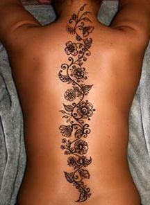 a woman's back tattoo with flowers and butterflies on it, as well as the bottom