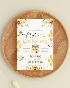 a wooden plate with a card on top of it that says, natas first bee - day