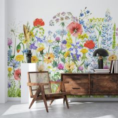 a room with flowers painted on the wall and two chairs in front of it,