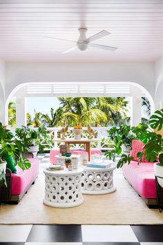 a living room filled with lots of furniture next to plants and potted planters